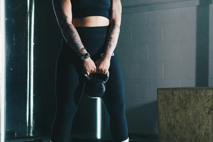 Donna che si allena con un kettlebell in palestra